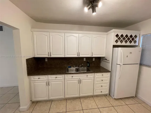 a kitchen with white cabinets and white appliances