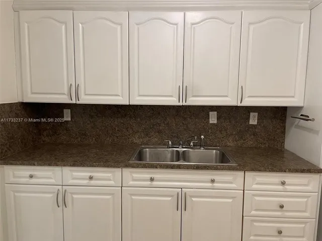 a kitchen with white cabinets and white appliances