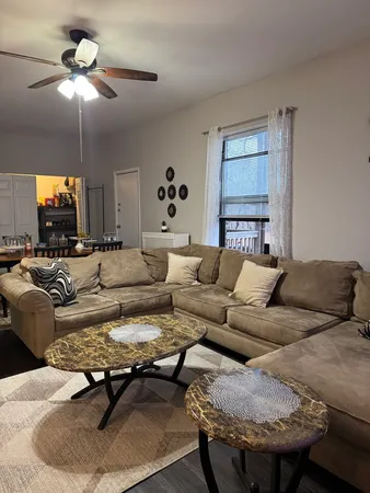 a living room with furniture and a ceiling fan