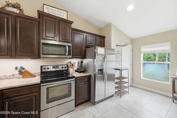 a kitchen with stainless steel appliances granite countertop a refrigerator stove and microwave