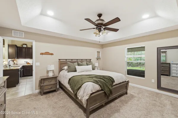 a spacious bedroom with a bed and ceiling fan