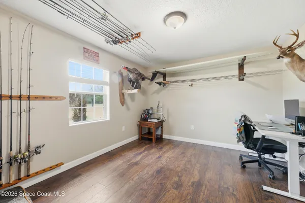 a view of a room with gym equipment on wooden floor