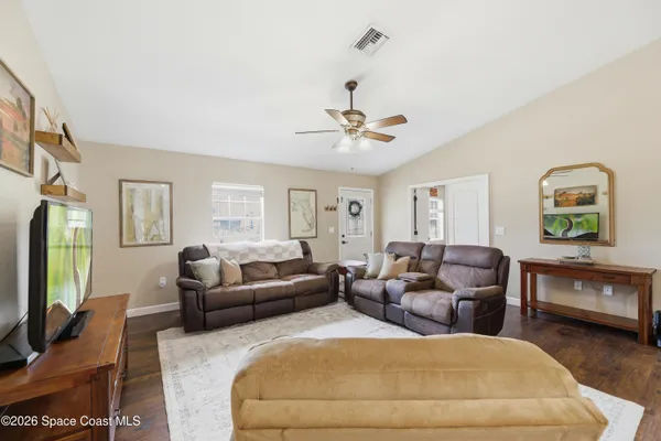 a living room with furniture a flat screen tv and a window