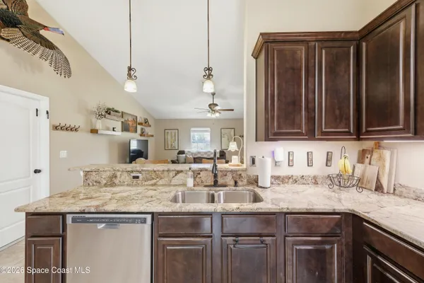 a kitchen with granite countertop a sink and cabinets