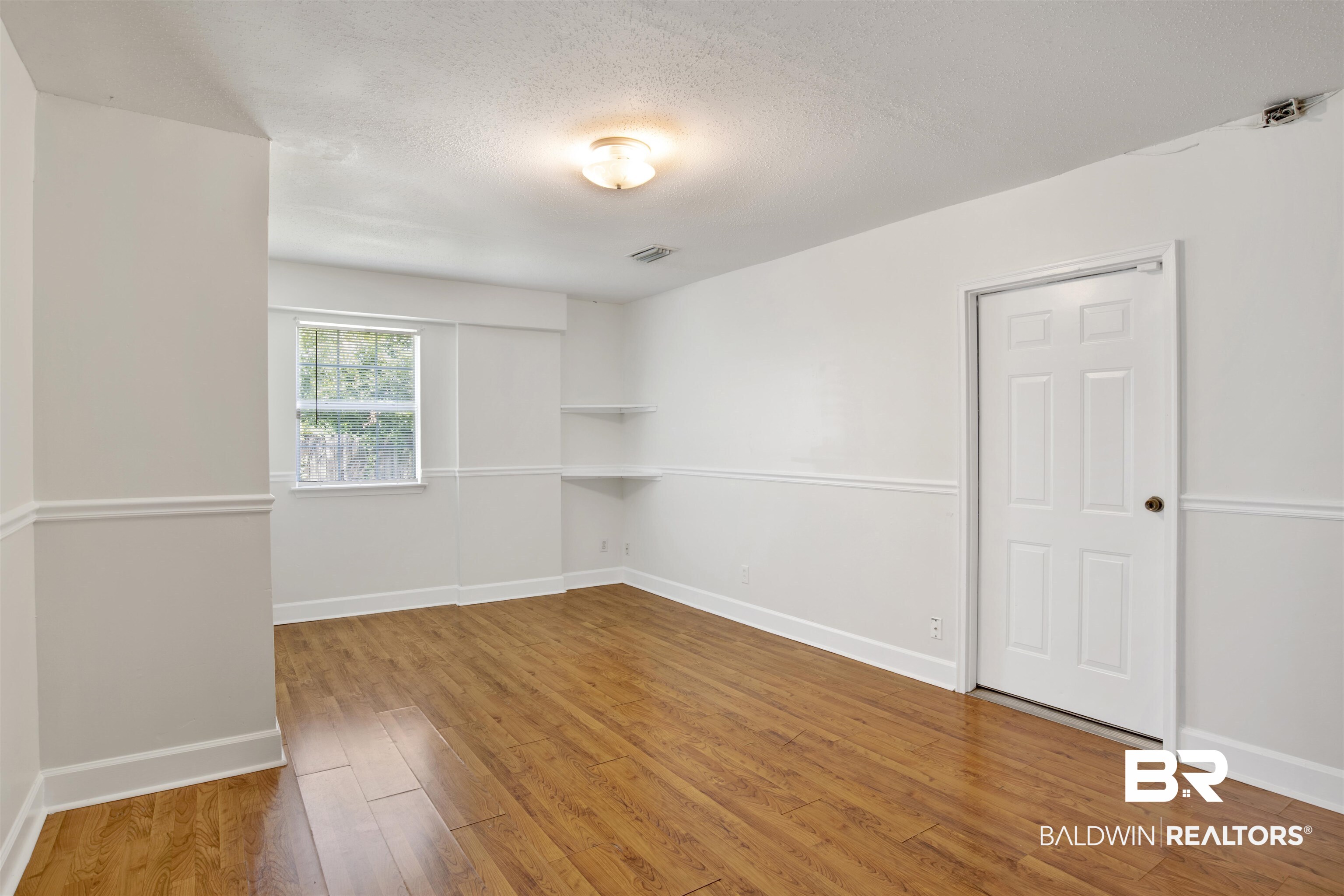 5480 Country Club Boulevard Theodore, AL 36582 - Photo 18 of 36 Empty room with a textured ceiling and hardwood / wood-style flooring