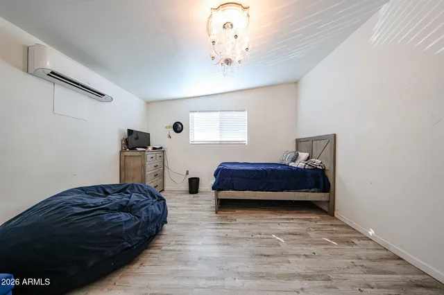 a spacious bedroom with a bed and a chandelier