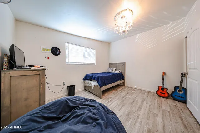 a bedroom with a bed and a chandelier