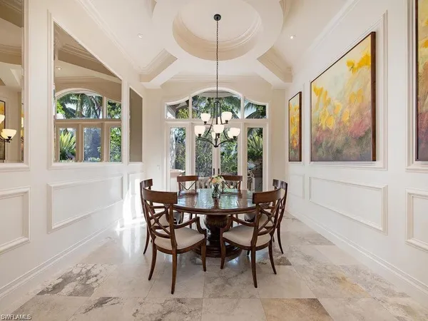 a view of a dining room with furniture a chandelier and wooden floor