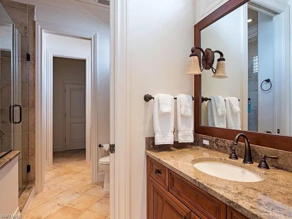 a bathroom with a granite countertop sink and a mirror