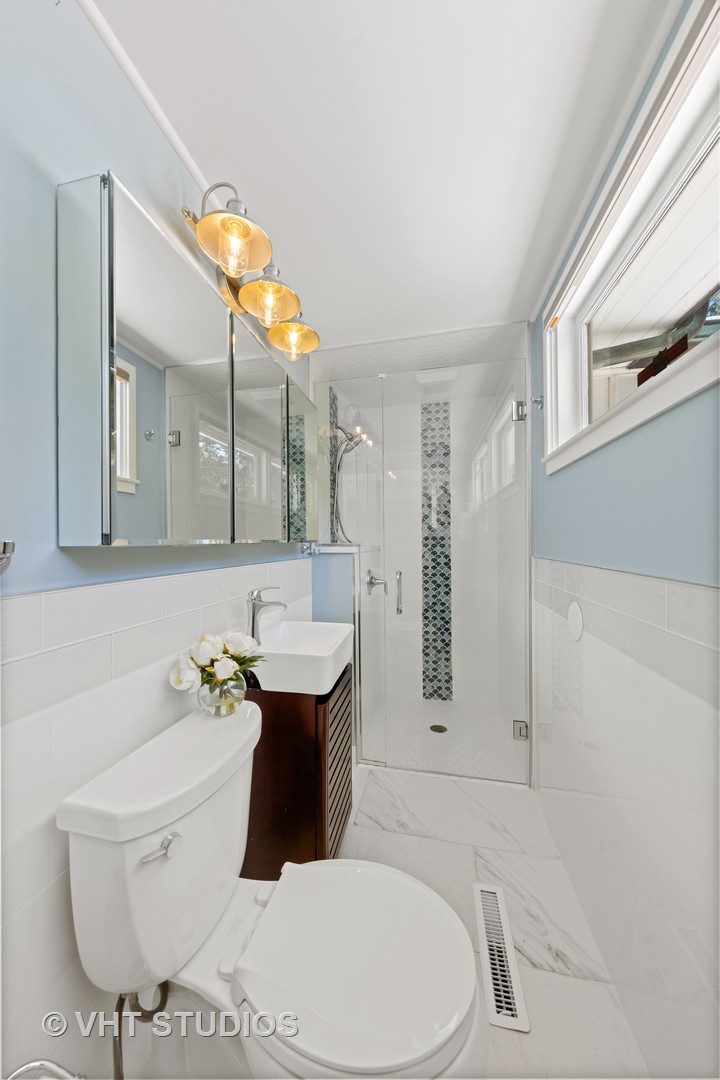 6547 South County Line Road Burr Ridge, IL 60527 - Photo 21 of 59 a bathroom with a sink a toilet and mirror