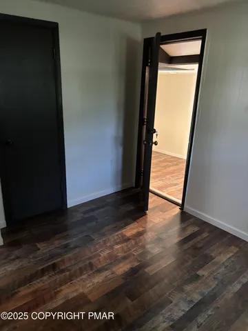 an empty room with wooden floor and a window