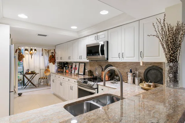 a kitchen with stainless steel appliances granite countertop a sink and cabinets
