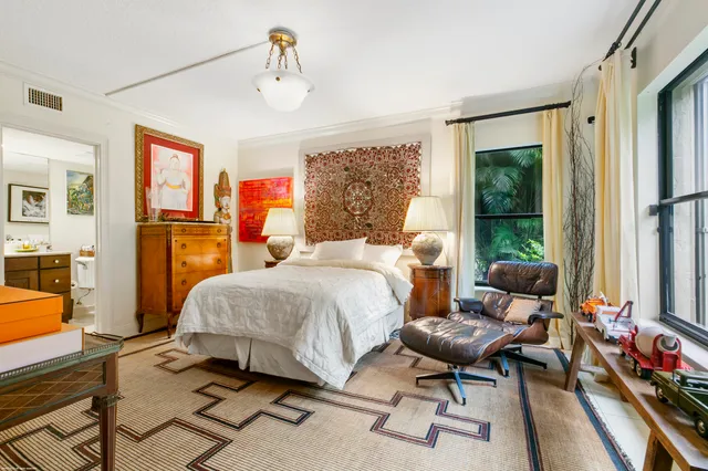 a bedroom with a bed and large windows