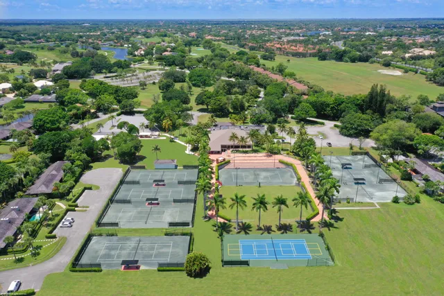 an aerial view of residential houses with outdoor space and trees