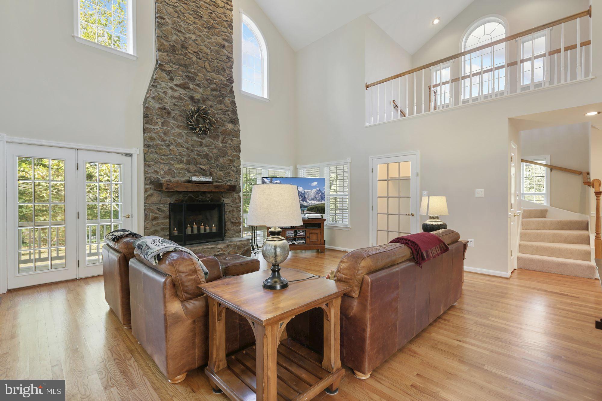 Dramatic 2 story living room with stone fireplace