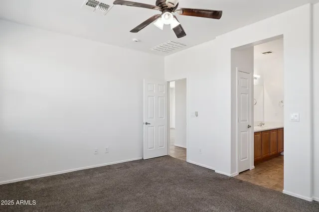an empty room with a ceiling fan and a window