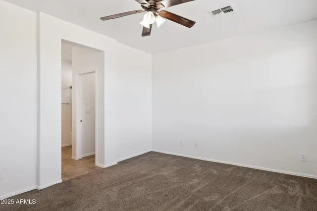 a view of a refrigerator in kitchen and white cabinets