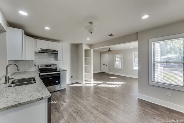 a kitchen with granite countertop a stove and a sink
