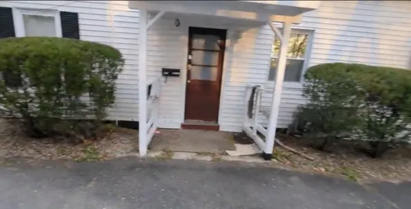 a brick house with a yard and plants