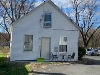 a brick house with tree in front of it