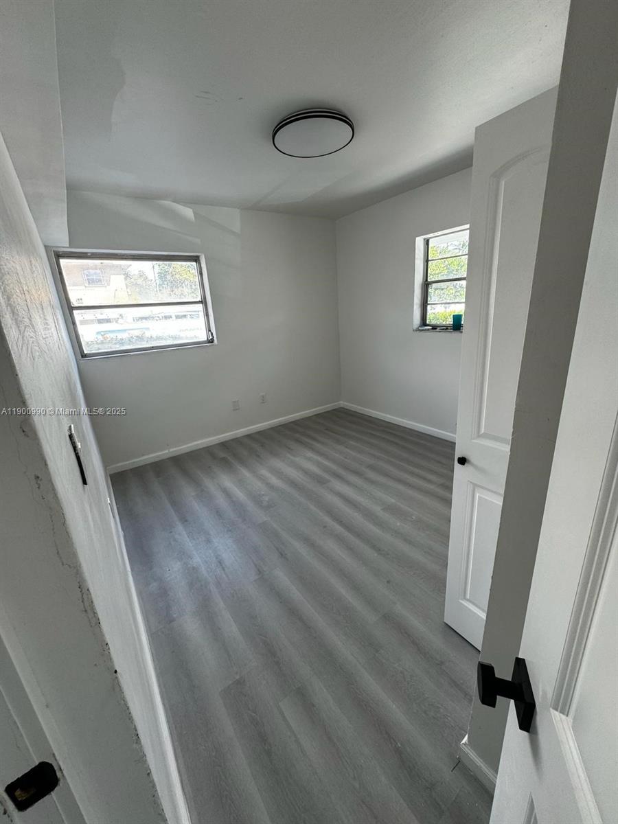 602 Southwest 13th Avenue, Unit 4 Miami, FL 33135 - Photo 12 of 13 a view of an empty room with wooden floor and a window