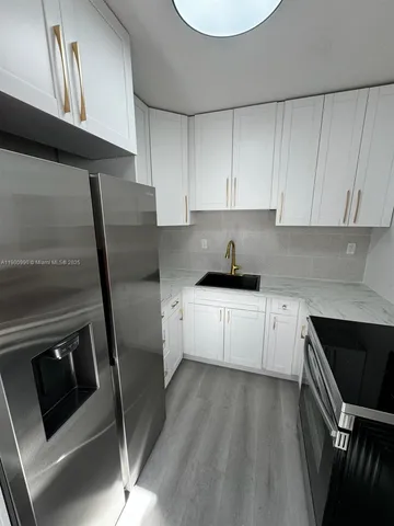 a kitchen with a sink a microwave a refrigerator and cabinets
