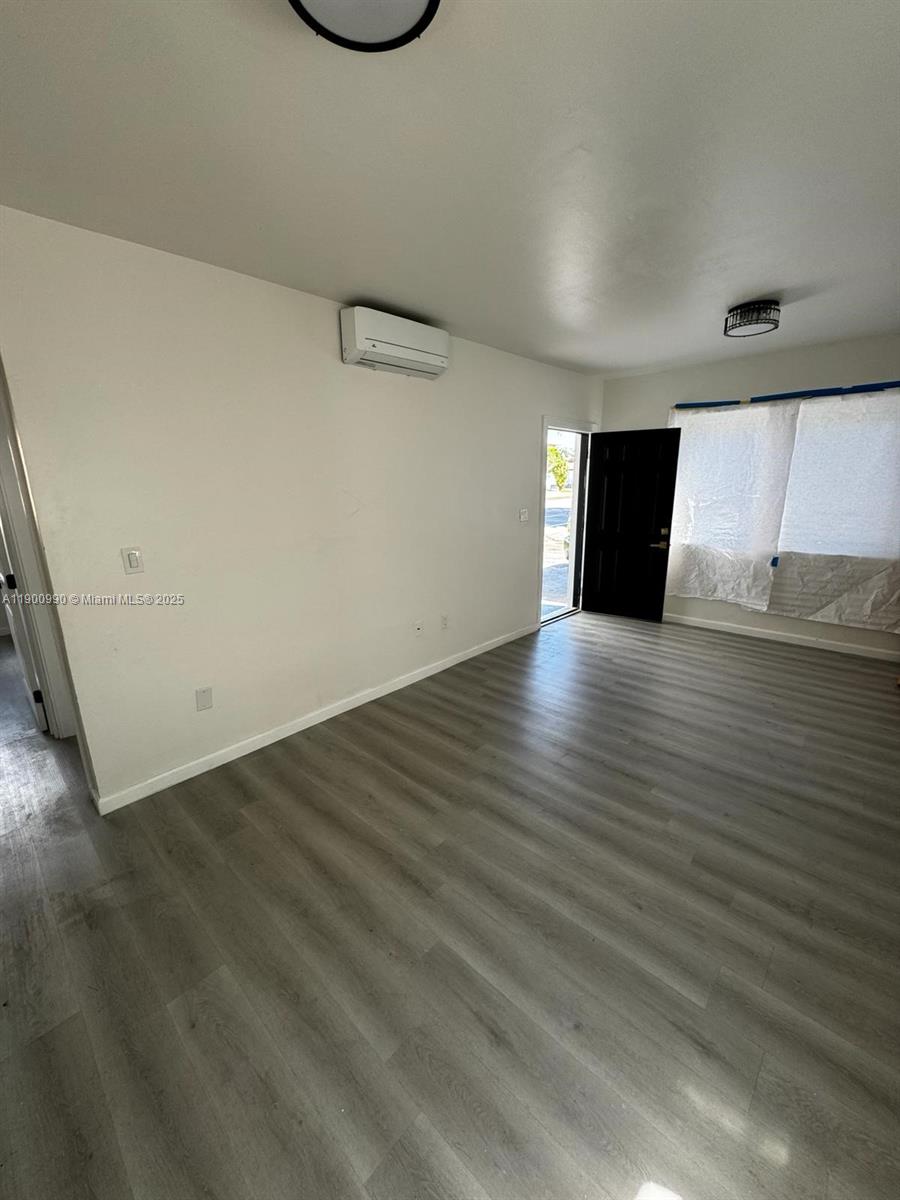 602 Southwest 13th Avenue, Unit 4 Miami, FL 33135 - Photo 8 of 13 a view of an empty room with wooden floor and a window