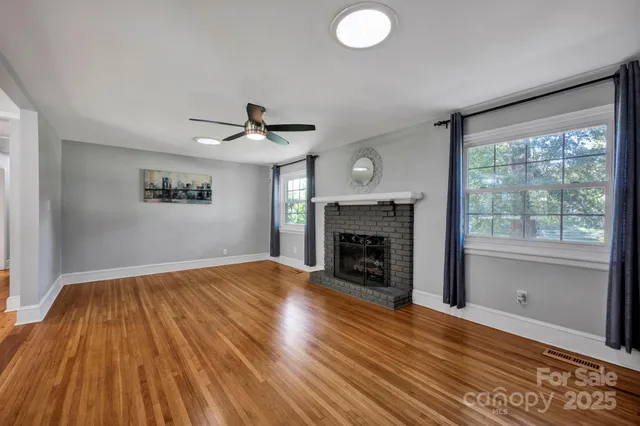 a view of empty room with wooden floor and fireplace