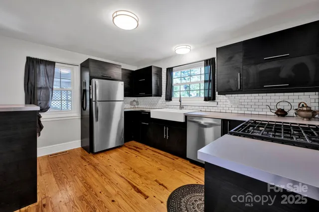 a kitchen with stainless steel appliances kitchen island granite countertop a refrigerator stove top oven a sink and dishwasher