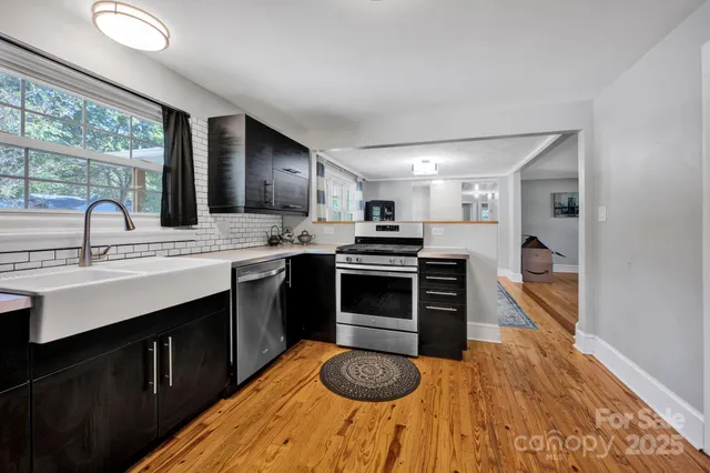 a kitchen with stainless steel appliances granite countertop a sink stove and cabinets