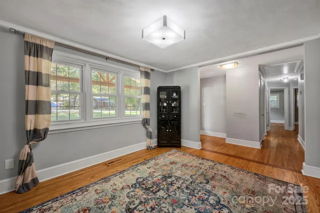 a view of an empty room with window and bathroom
