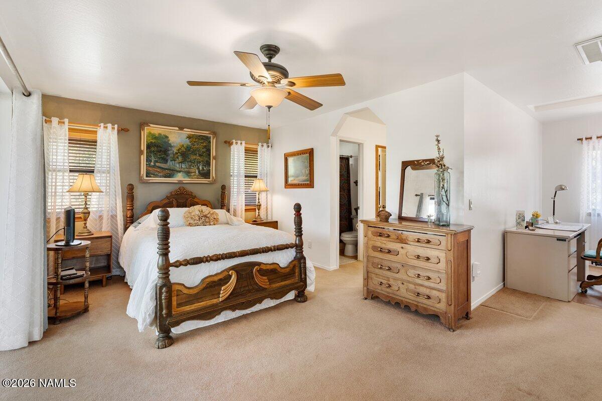 5535 East Western Star Road Flagstaff, AZ 86004 - Photo 21 of 44 a bedroom with a bed and a chandelier