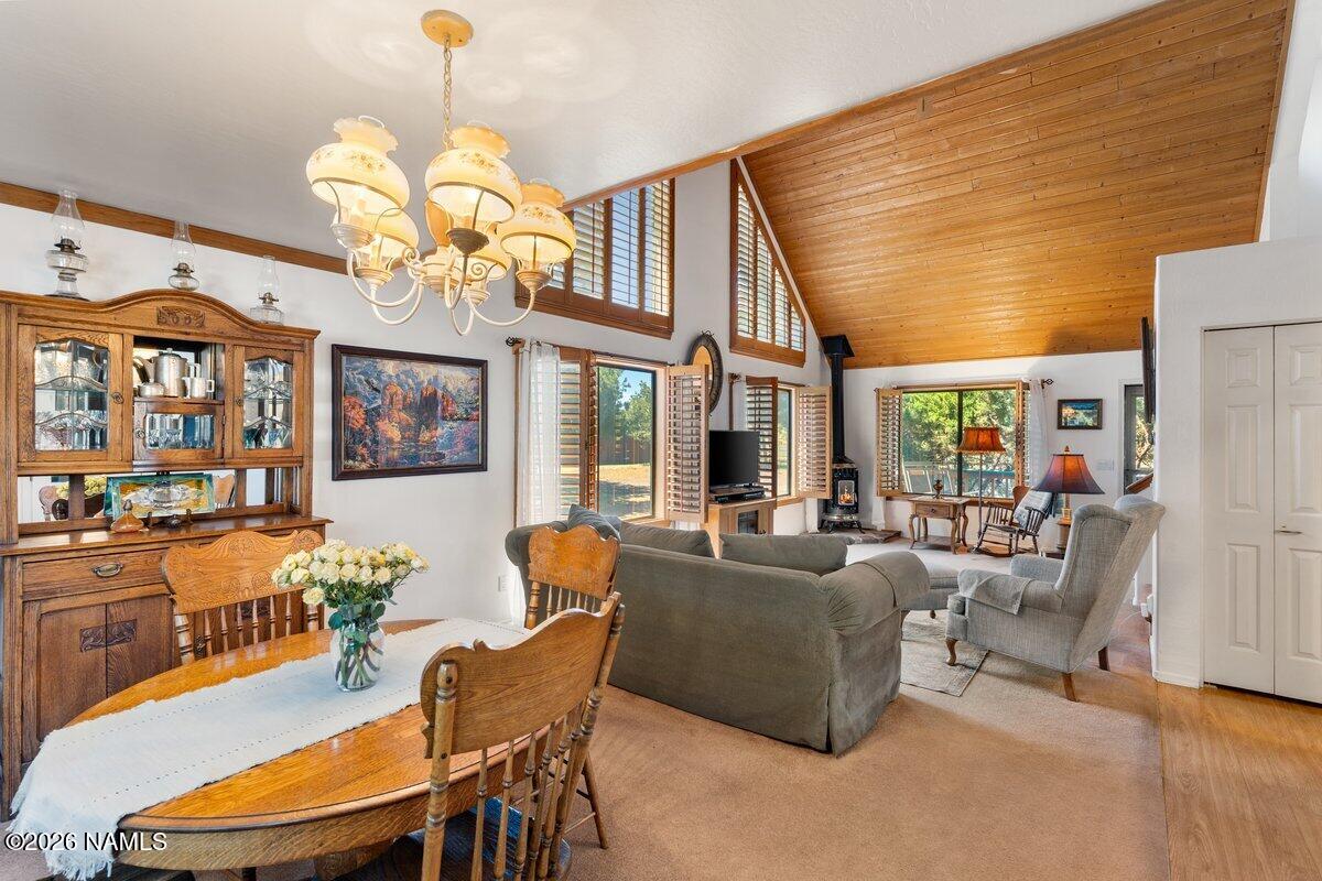 5535 East Western Star Road Flagstaff, AZ 86004 - Photo 7 of 44 a dining room with wooden floor a chandelier a glass table and chairs