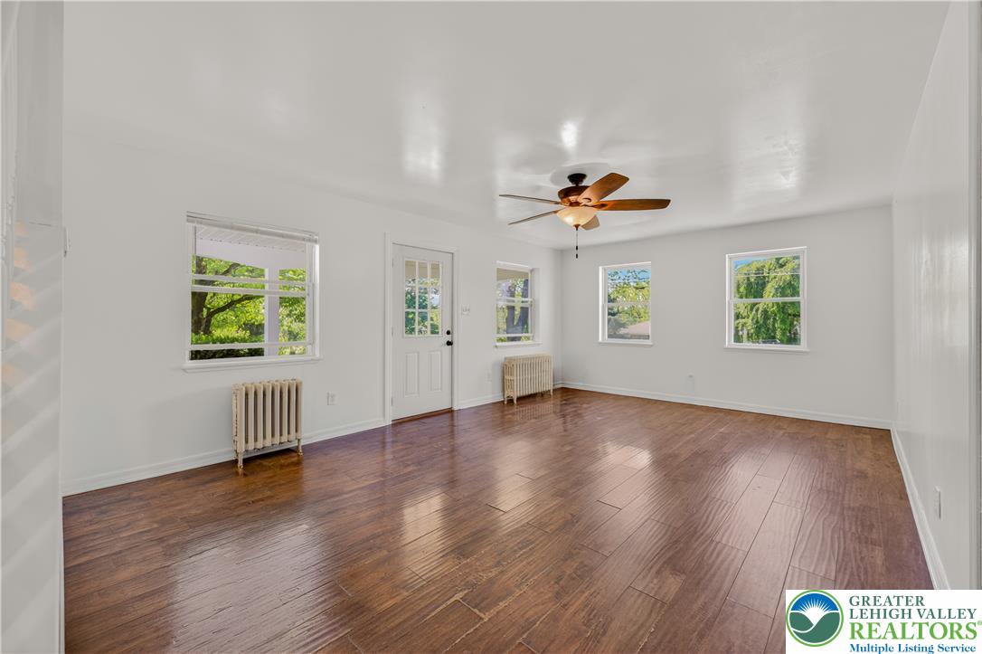 1411 Lieb Road Easton, PA 18040 - Photo 16 of 46 Warm hardwood floors and a ceiling fan create an inviting atmosphere in this sun-filled living space.