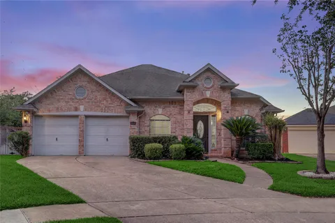 a front view of a house with a garden and garage
