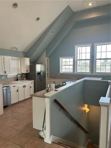 a view of an empty room with window and stairs