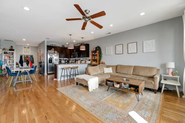a living room with furniture and a wooden floor