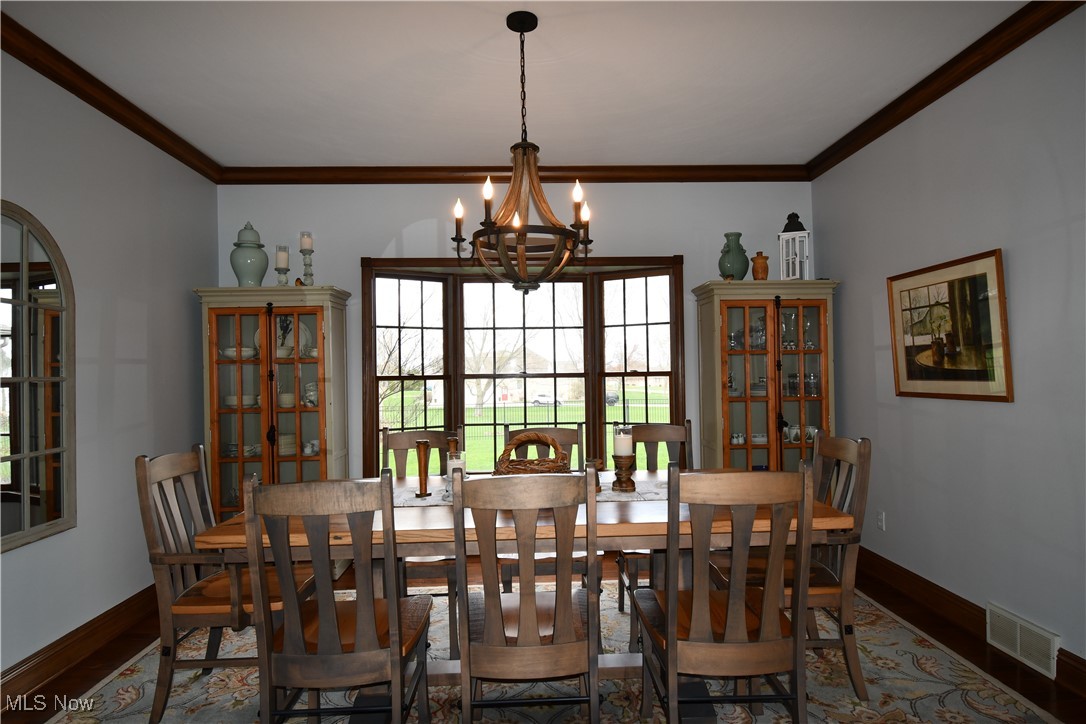3180 West Calla Road Canfield, OH 44406 - Photo 7 of 49 Dining room featuring a chandelier, wood finished floors, ornamental molding, and visible vents