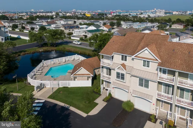 a view of a white house with pool and sitting area