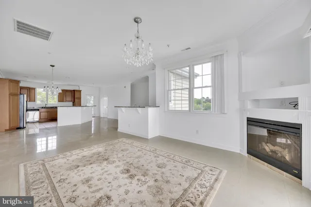a view of a living room and kitchen with furniture wooden floor and a fireplace