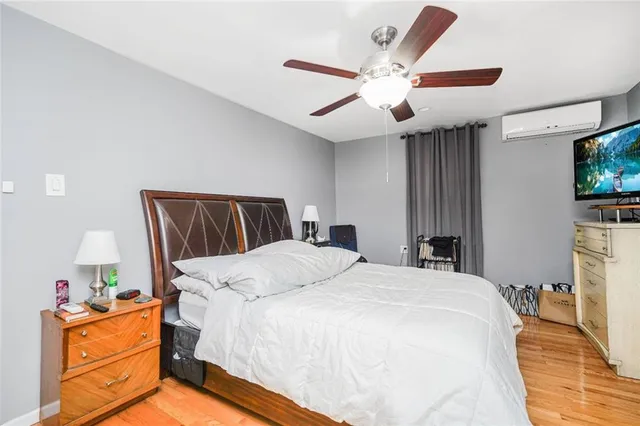 a bedroom with a bed and a flat tv screen on dresser