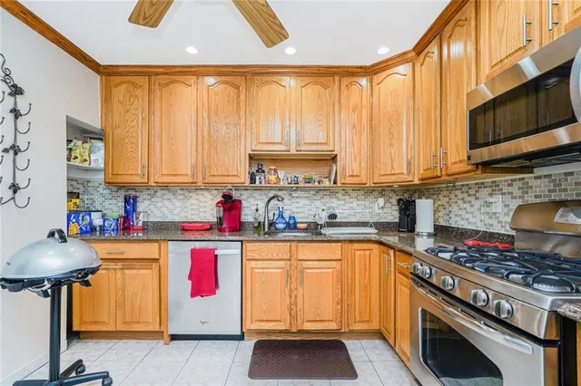 a kitchen with granite countertop a sink stainless steel appliances and counter space