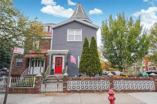 a front view of a house with a tree