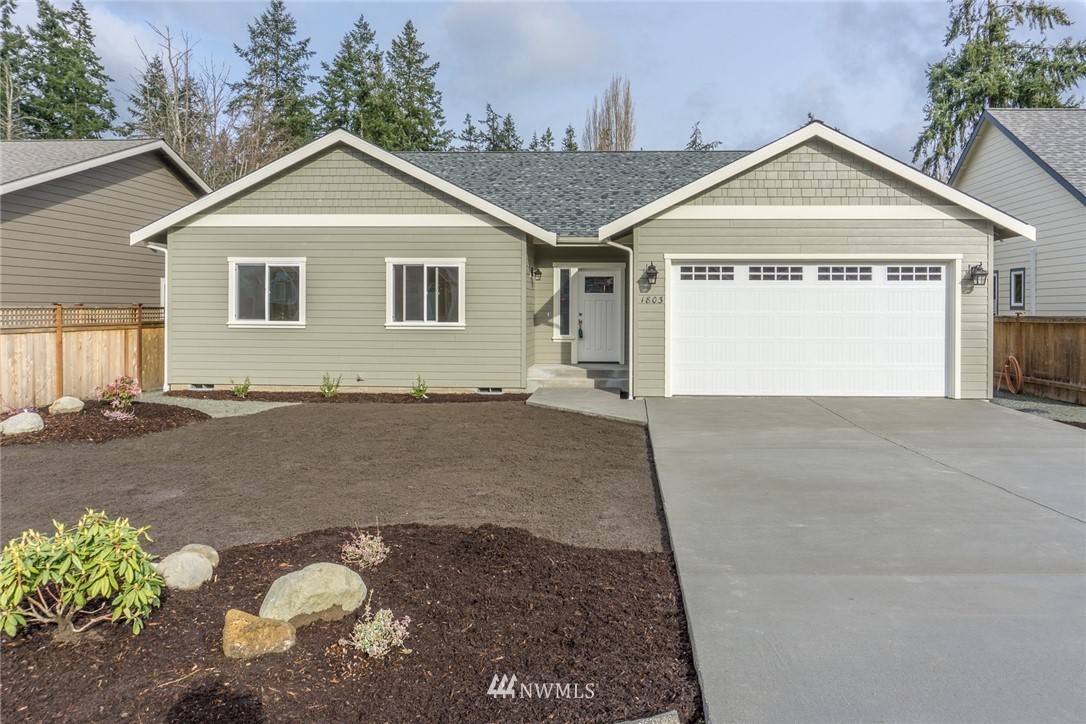 1803 Watkins Road Freeland, WA 98249 - Photo 1 of 25 a front view of a house with a yard and garage
