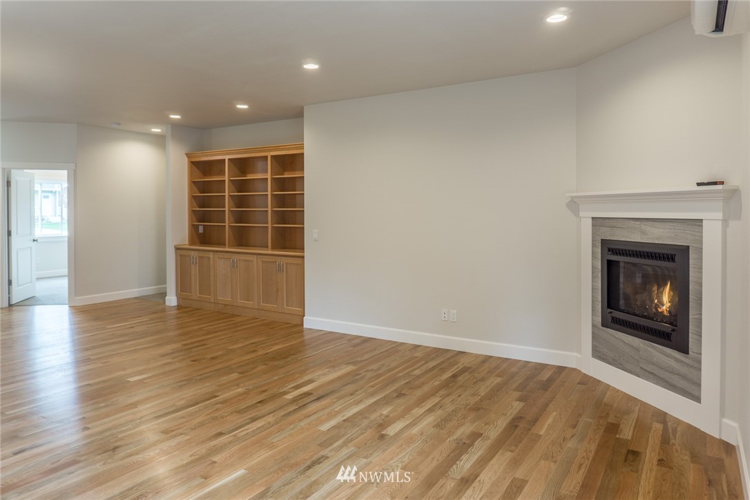 1803 Watkins Road Freeland, WA 98249 - Photo 6 of 25 an empty room with wooden floor and fireplace
