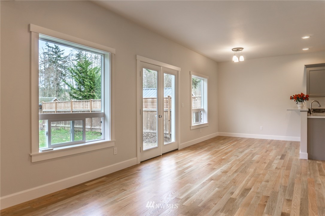 1803 Watkins Road Freeland, WA 98249 - Photo 7 of 25 a view of an empty room with wooden floor and a window
