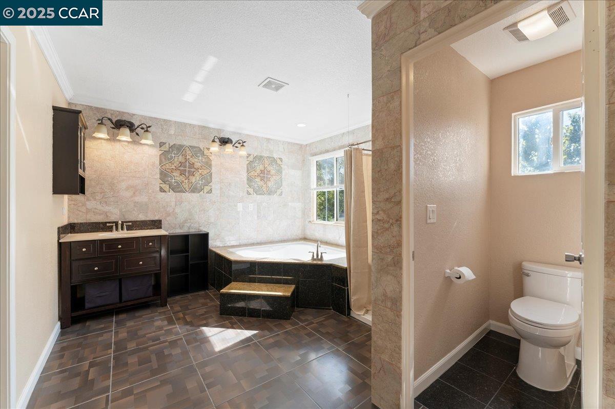 4651 Shetland Way Antioch, CA 94531 - Photo 22 of 34 a spacious bathroom with a granite countertop sink toilet and a mirror