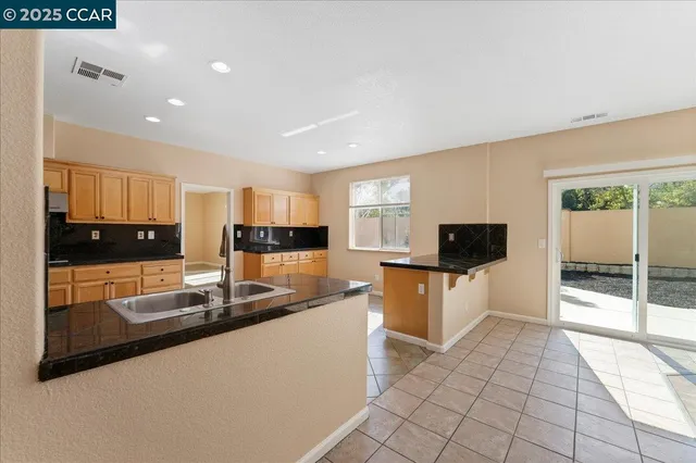 a kitchen with stainless steel appliances granite countertop a sink and a stove