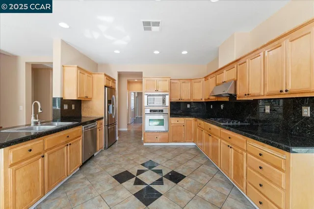 a large kitchen with stainless steel appliances and cabinets