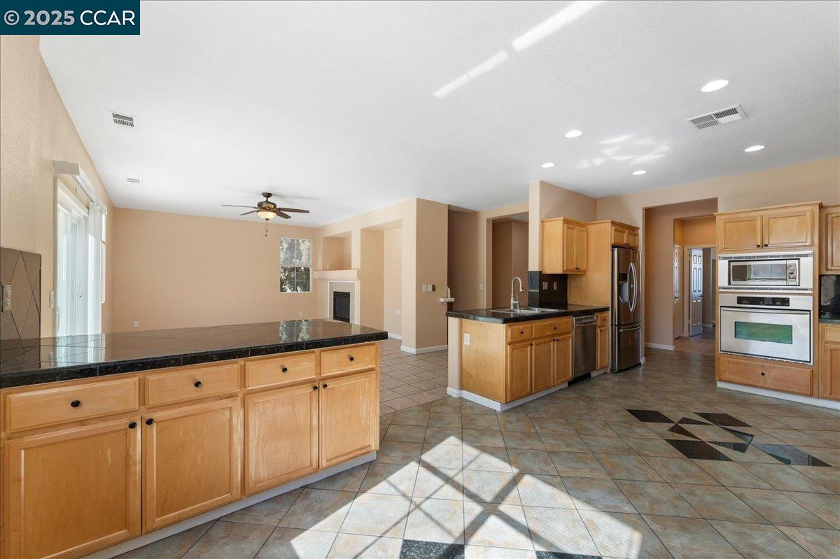 4651 Shetland Way Antioch, CA 94531 - Photo 8 of 34 a large kitchen with stainless steel appliances kitchen island granite countertop a refrigerator and a sink